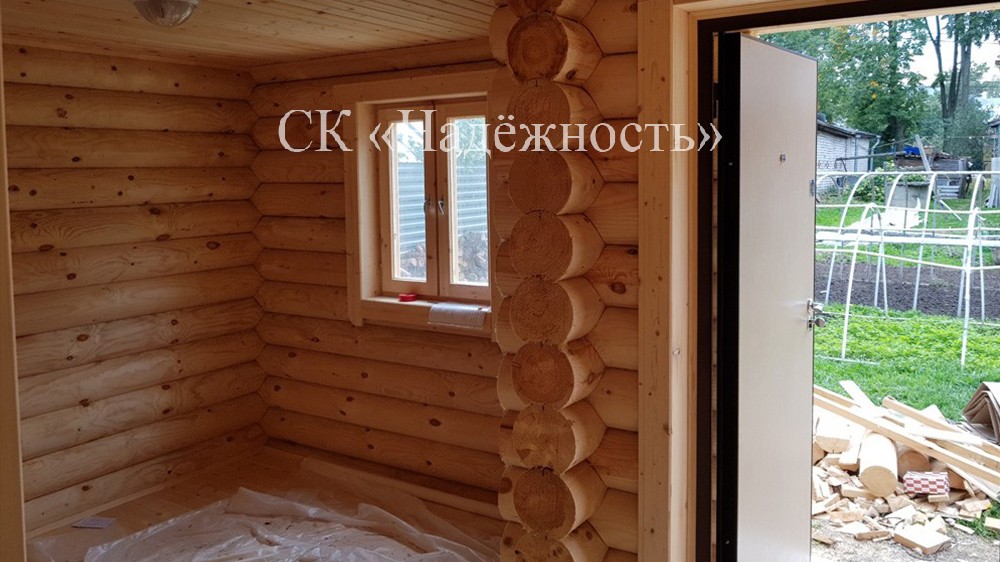 Деревянное окно в доме, построенном из оцилиндрованного бревна
