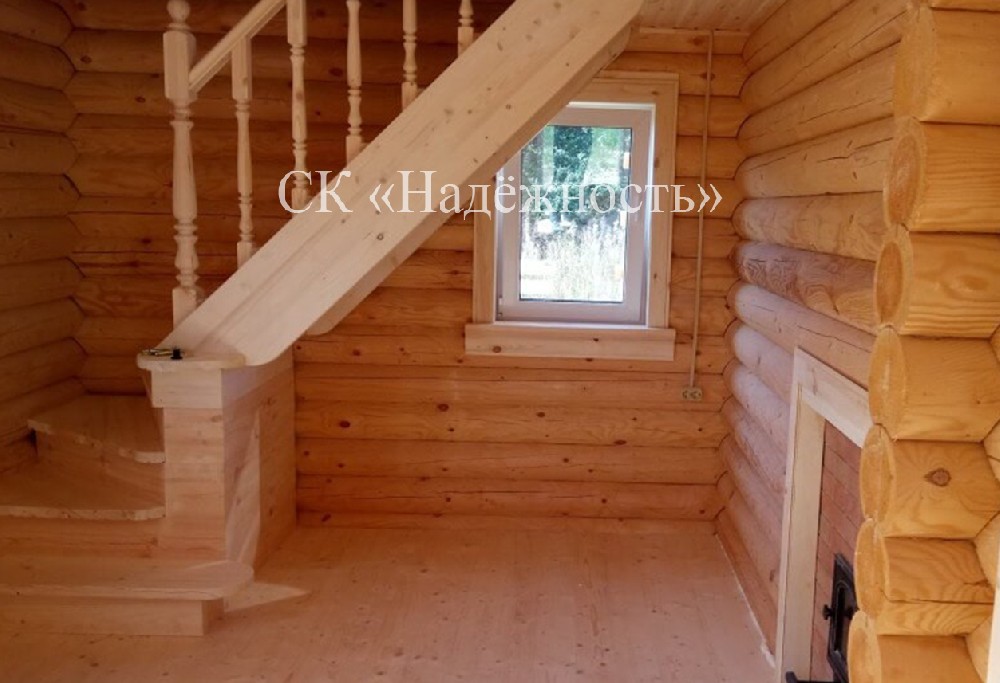 Деревянная лестница с поворотной площадкой в доме, построенном из оцилиндрованного бревна
